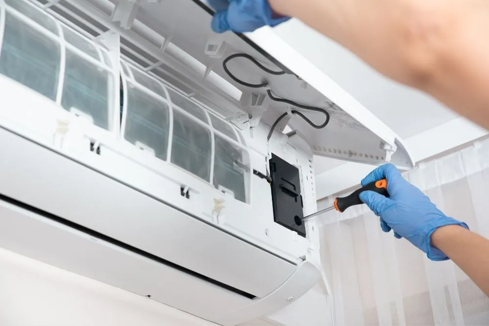 Technician servicing a wall-mounted split system air conditioner