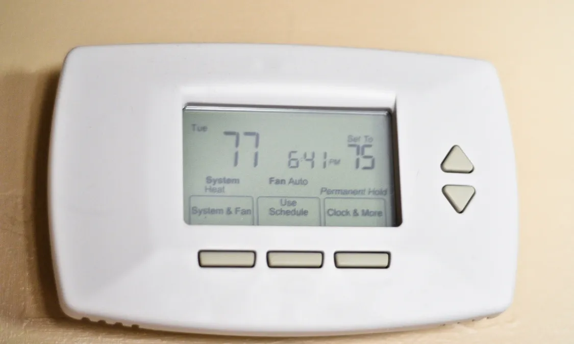 white thermostat installed at the wall