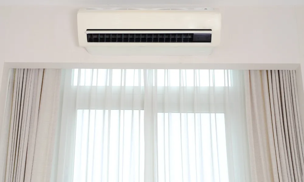 White air conditioner installed in wall and curtains